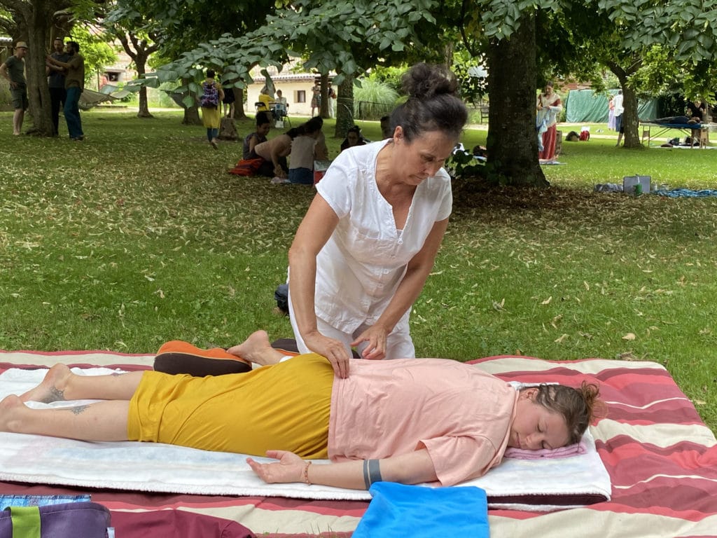 Praticienne massage bien-être masse une femme allongée sur le dos